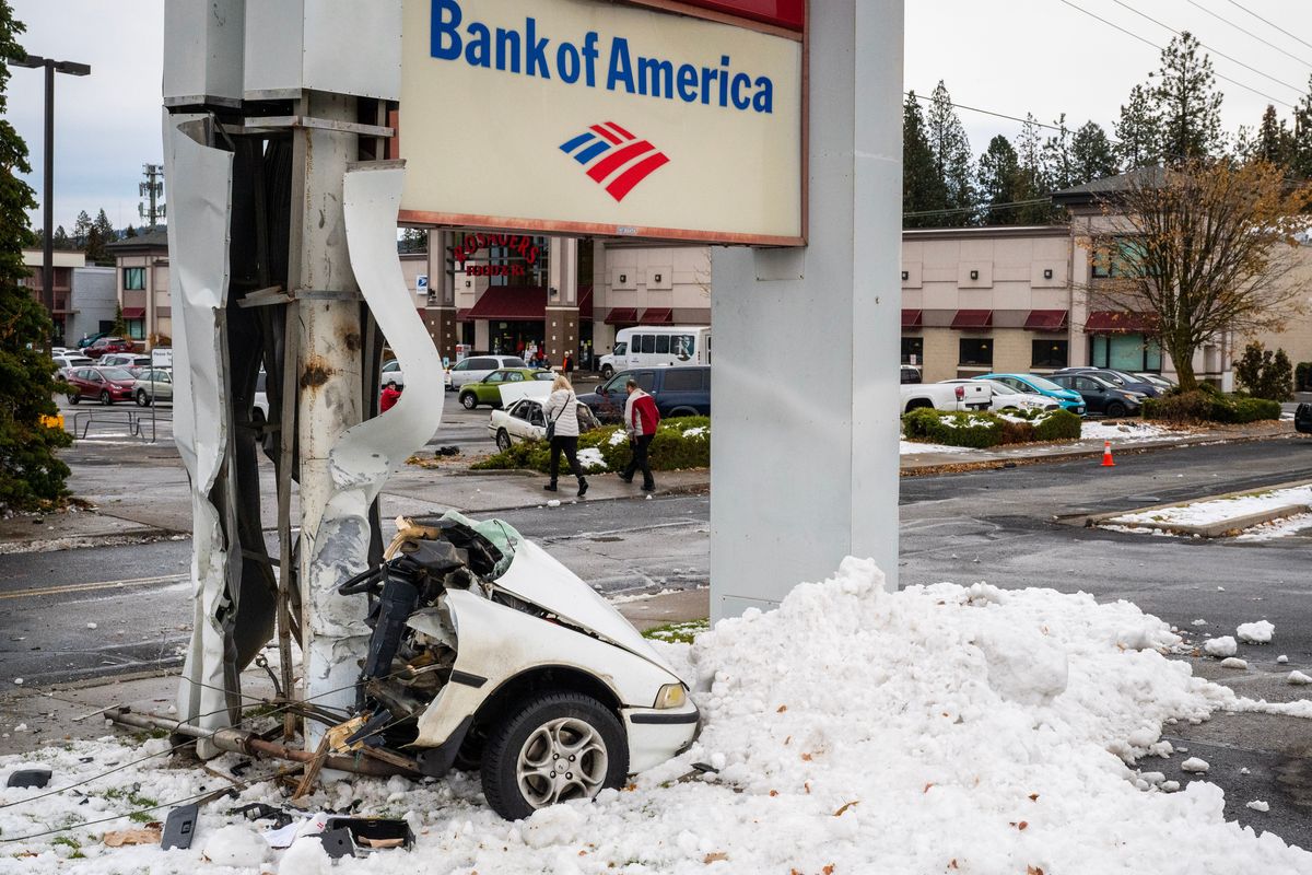 A driver of this vehicle lost control as he was heading east on 29th Avenue and struck the Bank of America sign on 2504 E. 29th Ave. on Friday morning. The driver was ejected as the car split in two from the impact with the sign post. He was transported to Providence Sacred Heart Medical Center.  (COLIN MULVANY/THE SPOKESMAN-REVI)
