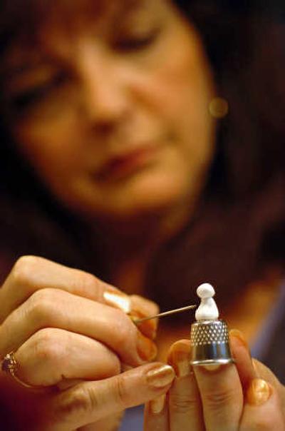 
Darlene Hardenbrook uses a thimble and needle to mold clay for jewelry. Her work, marketed as Little Darlins, can be found at Pottery Place Plus. 
 (INGRID BARRENTINE / The Spokesman-Review)