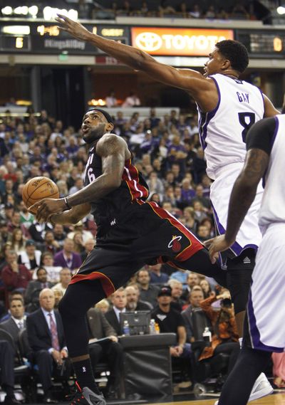 Miami’s LeBron James shoots against Sacramento’s Rudy Gay. The Kings won 108-103 in overtime. (Associated Press)