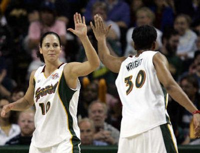 
Sue Bird, left, congratulates teammate Tanisha Wright after Wright scored in Seattle's season-opening victory. 
 (Associated Press / The Spokesman-Review)