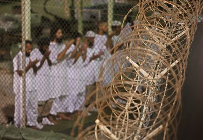 In this May 14 photo reviewed by the U.S. military, detainees pray before dawn near a razor wire fence in the Camp 4 detention facility at Guantanamo Bay, Cuba.  (Associated Press / The Spokesman-Review)