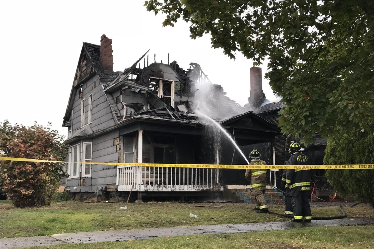 Two firefighters were injured and at least a dozen people displaced early Thursday, Oct. 4, 2018 after a house fire spread to another home and a garage at Ruby Street and Sinto Avenue. (Jonathan Glover / The Spokesman-Review)