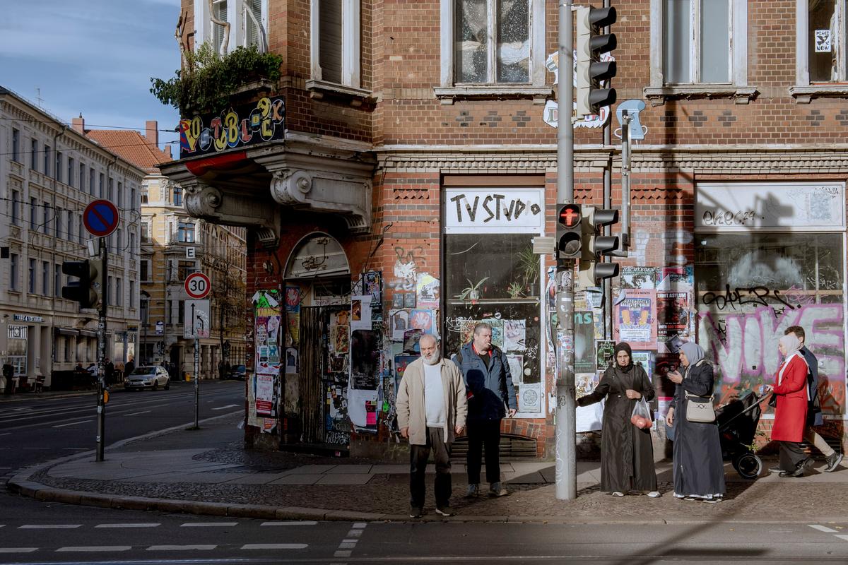 People stand on a sidewalk on Nov. 6, 2025 in Leipzig, Germany. Leipzig and other German cities have large immigrant populations.  (New York Times )