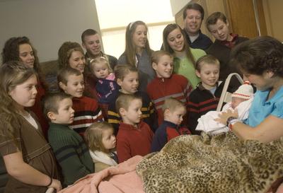Michelle Duggar holds her newborn daughter, Jordyn-Grace Mikaya Duggar, as 16 of her other children and husband, Jim Bob, second from the top right, watch on  Dec. 19 in Rogers, Ark.  (Associated Press / The Spokesman-Review)