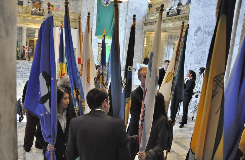 OLYMPIA -- Legislative staff waits at the doors to the state Senate with flags of Washington's 39 counties that will be brought in for the session's opening ceremony. (Jim Camden/The Spokesman-Review)
