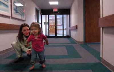 
Phoebe Rux, 3, runs from her mom, Tanya Rux, and to St. Luke's physical therapist Karen Armstrong (not pictured), during an assesment of the child. 
 (Jed Conklin / The Spokesman-Review)