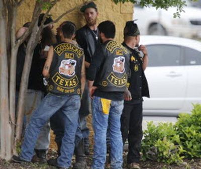 Bikers congregate against a wall while authorities investigate a Twin Peaks restaurant today in Waco, Texas. (Rod Aydelotte/Waco Tribune-Herald )
