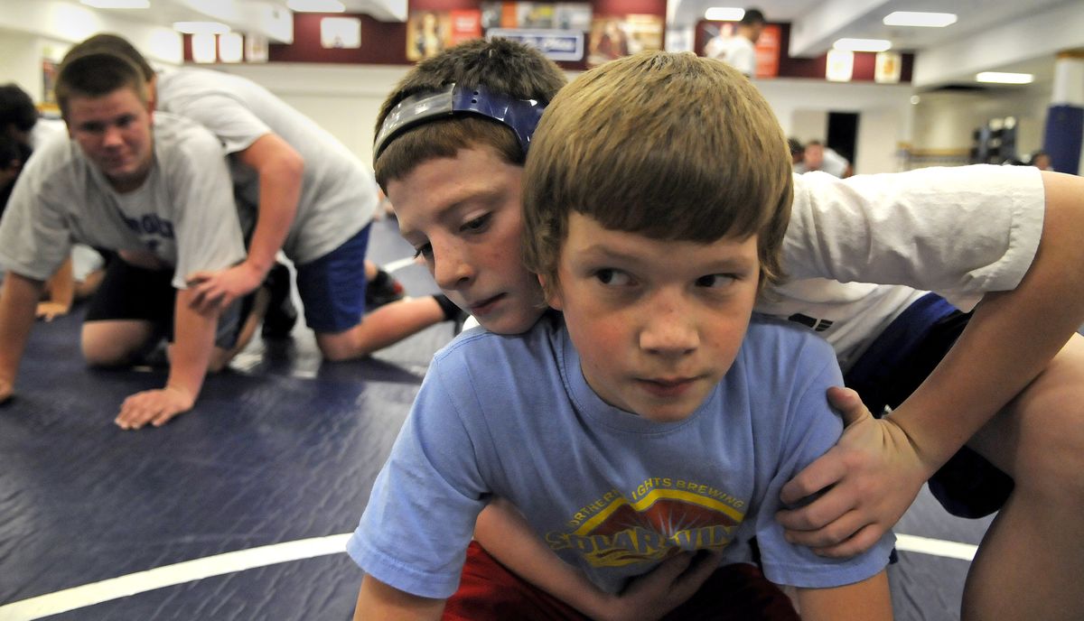 Payton Irvin, 12, right, and Nathan Casey, 12, prepare to do battle during wrestling practice Tuesday at Chase Middle School. Sports at middle schools could be vulnerable to tough economic times. (Dan Pelle)