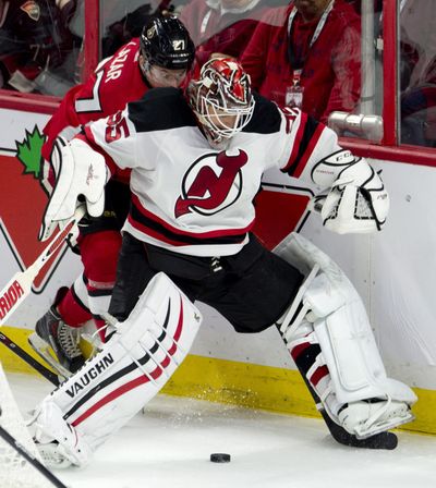 New Jersey goalie Cory Schneider collides with Ottawa right wing Curtis Lazar during the second period of the Devils’ OT win. (Associated Press)
