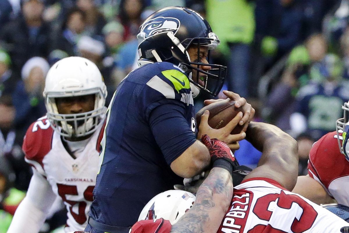 Seahawks quarterback Russell Wilson is held back by Arizona Cardinals defensive end Calais Campbell (93) in a goal line situation on Saturday, Dec. 24, 2016, in Seattle. (Ted S. Warren / Associated Press)