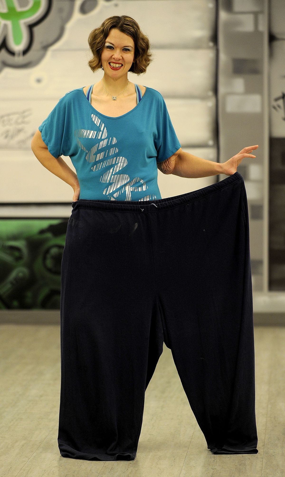 Jenny Duncan shows off her “before pants” at The Body Shop in Coeur d’Alene. She lost more 300 pounds through exercise and Weight Watchers. (Kathy Plonka)
