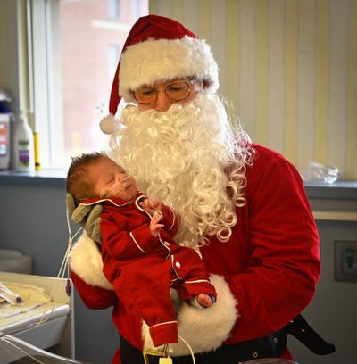 Santa Claus, portrayed by NICU nurse Dustan Braun, holds Hayden Hund in the neonatal intensive care unit at MultiCare Deaconess Hospital Tuesday. Braun carefully held every baby for photos for the families.  (Jesse Tinsley/THE SPOKESMAN-REVI)