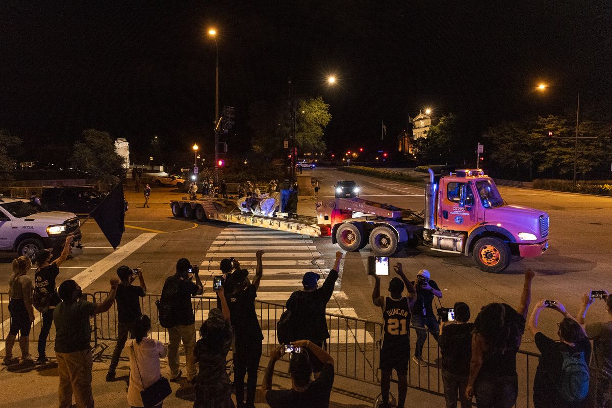 A group of people in support of the removal of the Christopher Columbus statue cheer as the it is driven away from Grant Park, Friday, July 24, 2020, in Chicago. The statue of Christopher Columbus that drew chaotic protests in Chicago was taken down early Friday amid a plan by President Donald Trump to dispatch federal agents to the city.  (Tyler LaRiviere/Sun-Times)