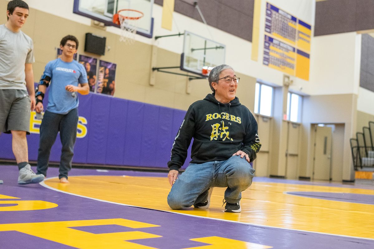 Rogers wrestling coach Rod Tamura jokes with his team before practice on Friday at Rogers High School in Spokane.  (Madison McCord/For The Spokesman-Review)