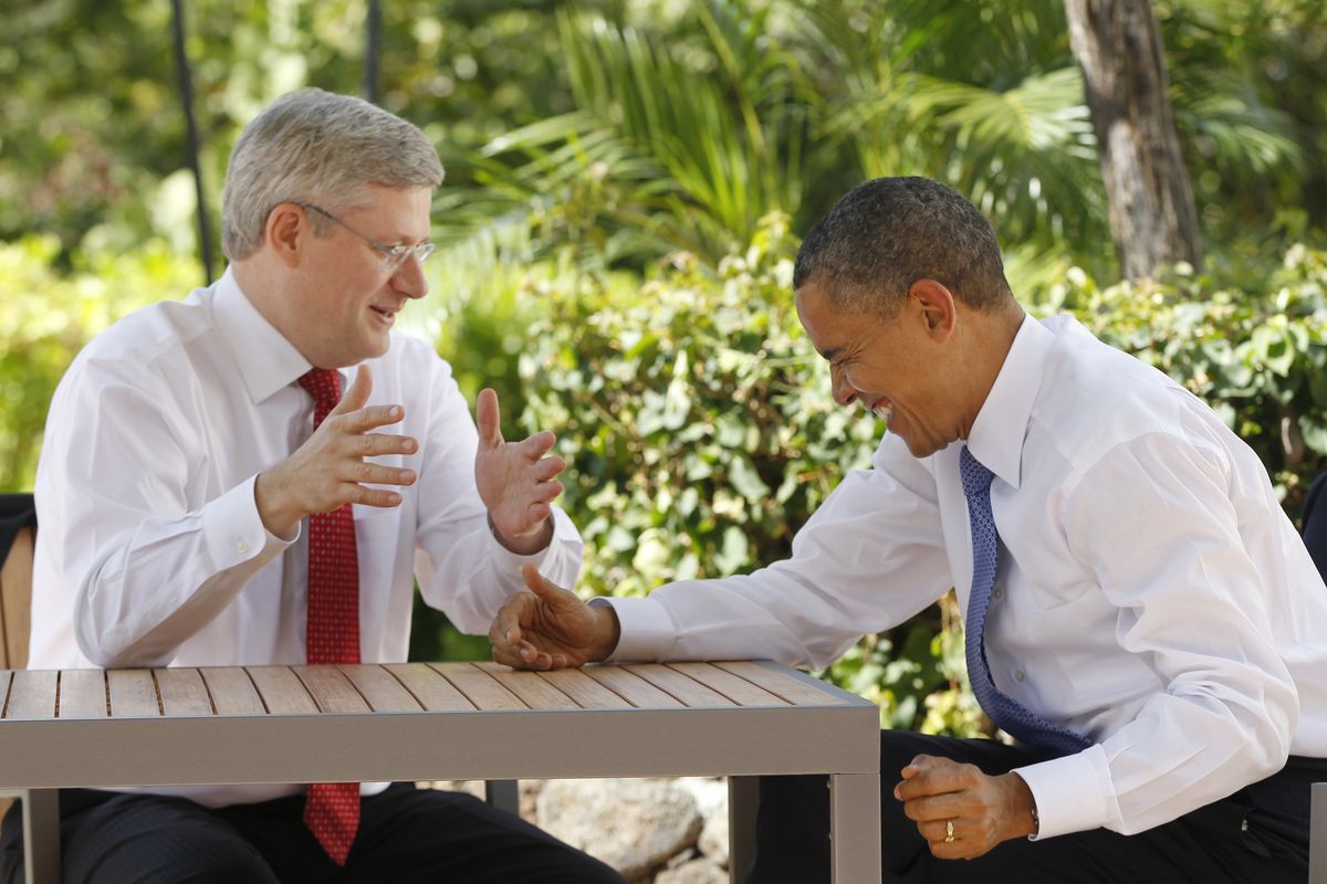 Canadian Prime Minister Stephen Harper, left, talks with U.S. President Barack Obama following the first plenary session of the Asia-Pacific Economic Cooperation summit on Sunday in Kapolei, Hawaii. (Associated Press)