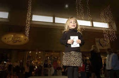 
Ella Stephens, 4, stands on the runway and holds her number while being photographed  during an audition for the Festival of Trees fashion show. 
 (Jesse Tinsley / The Spokesman-Review)