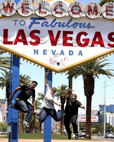 ORG XMIT: NVLAS201 From left, Arizona tourists Joseph Harris,17, Laura Massengale,17, and Emily Viramontes,17, pose for photos by their friends in front of the graffiti blemished historical 