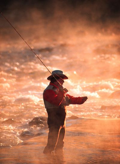 In this undated file photo, a fly fisherman casts his line as early morning mist rises above the Boise River, east of Boise, Idaho. (Troy Maben / AP)