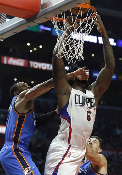 Los Angeles Clippers center DeAndre Jordan, center, gets fouled by Oklahoma City Thunder guard Russell Westbrook. (Alex Gallardo / Associated Press)