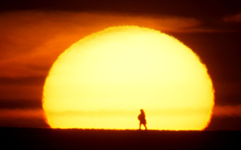A man is silhouetted as he walks on a road during a sunset near the town of Khoiniki, 300 kilometers (187 miles) south-east of the capital Minsk, Belarus, Wednesday, March 23, 2011. (Sergei Grits / Associated Press)