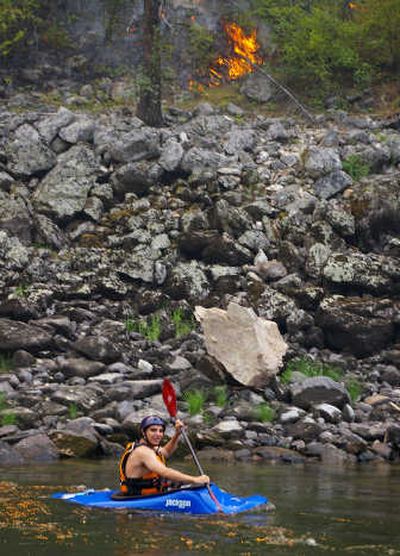 
Whitney Fish of Spokane kayaks past Salmon River forest fires just days before the flames spread and caused Forest Service officials to temporarily prohibit floaters from launching on the popular Central Idaho destination streams. Photo courtesy of Paul Fish
 (Photo courtesy of Paul Fish / The Spokesman-Review)