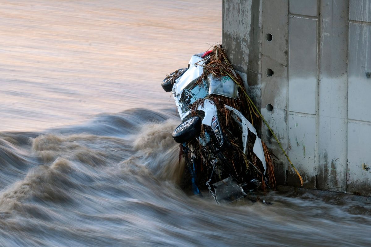 A vehicle is seen in the Los Angeles River at the Washington Bridge near downtown Los Angeles on Tuesday, Dec. 14, 2021. Rain is drenching Southern California as a blustery storm charged down the state, triggering river rescue efforts and raising the threat of mudslides in areas scarred by wildfires.  (Ringo H.W. Chiu)