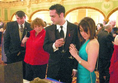 
Gonzaga students John Corrigan, center, and Liz Berryhill, right, look at auction items at the Spokane AIDS Network Oscar night gala. 
 (J. BART RAYNIAK / The Spokesman-Review)