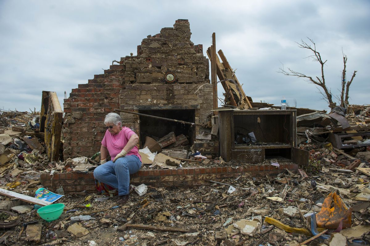 Norma Riley, of Blanchard, Okla., takes a break while helping her friend Travis Cotten pick through tornado debris on May 24, 2013, in Moore, Okla.  (Ricky Carioti/Washington Post)