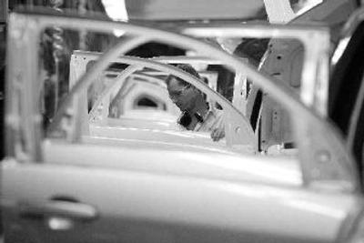 
A worker installs glass in doors and window openings on the trim line during production of General Motors' Chevrolet Equinox, Pontiac Torrent and Suzuki XL7 at the CAMI Automotive facility in Ingersoll, Ontario. 
 (Associated Press / The Spokesman-Review)