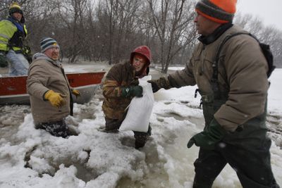 Jack Lubka, Dale Cardwell, Michael Stensgard and Doug Stensgard load sandbags as the Red River rises Wednesday in Fargo, N.D.  (Associated Press / The Spokesman-Review)