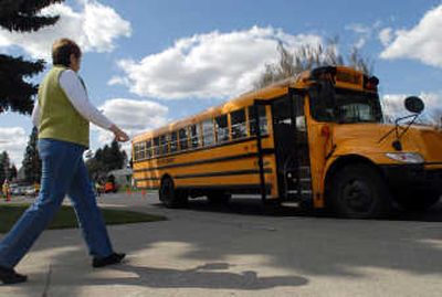 
Raelene Coster, assistant secretary at Madison Elementary in Spokane, walks out to the bus line after school. A bus from First Student, formerly Laidlaw, waits for students.  
 (Jesse Tinsley / The Spokesman-Review)