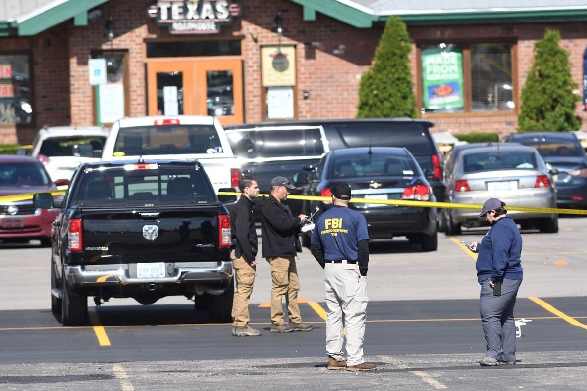 Members of the Federal Bureau of Investigation continue canvassing the parking lot at the Texas Roadhouse restaurant in Madison Heights, Mich., on Oct. 3 after Eric Mark-Matthew Allport was killed in a gunfight the previous night.  (Max Ortiz/The Detroit News)