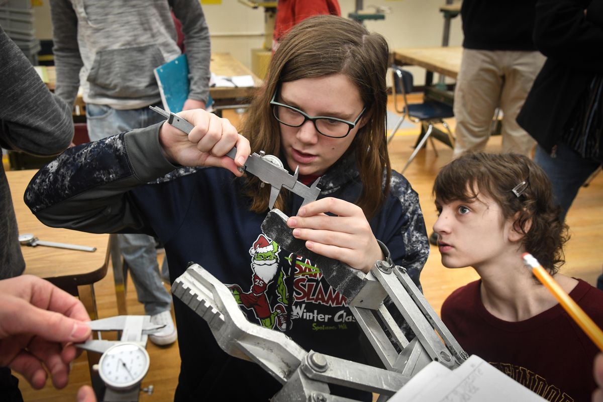 Sacajawea Middle School students Brooklyn Jenson, left, and Kaitlyn Hawker, measure the gripping pieces on a Spokane police department bomb robot, Thursday, Jan. 10, 2019. The advanced engineering students will be designing (using computer-aided design and drafting) and printing (using a 3D printer) parts that the SPD/FBI bomb squad can use to dramatically improve grip on its bomb disposal robots. (Dan Pelle / The Spokesman-Review)