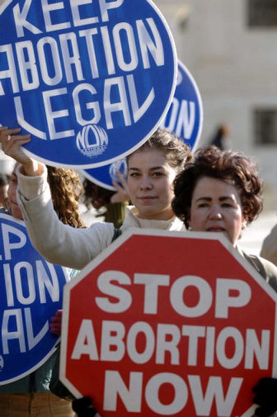 
Jordan Conn, of Rockville, Md., left, and Mary Susan Grayson, of Kensington, Md., hold signs supporting opposing views on abortion outside the U.S. Supreme Court on Wednesday. 
 (Associated Press / The Spokesman-Review)
