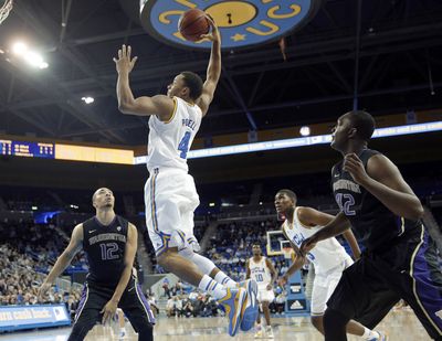 UCLA's Norman Powell, who scored game-high 24 points, goes up for a dunk as UW's Quevyn Winters, left, and Donaven Dorsey look on. (Associated Press)