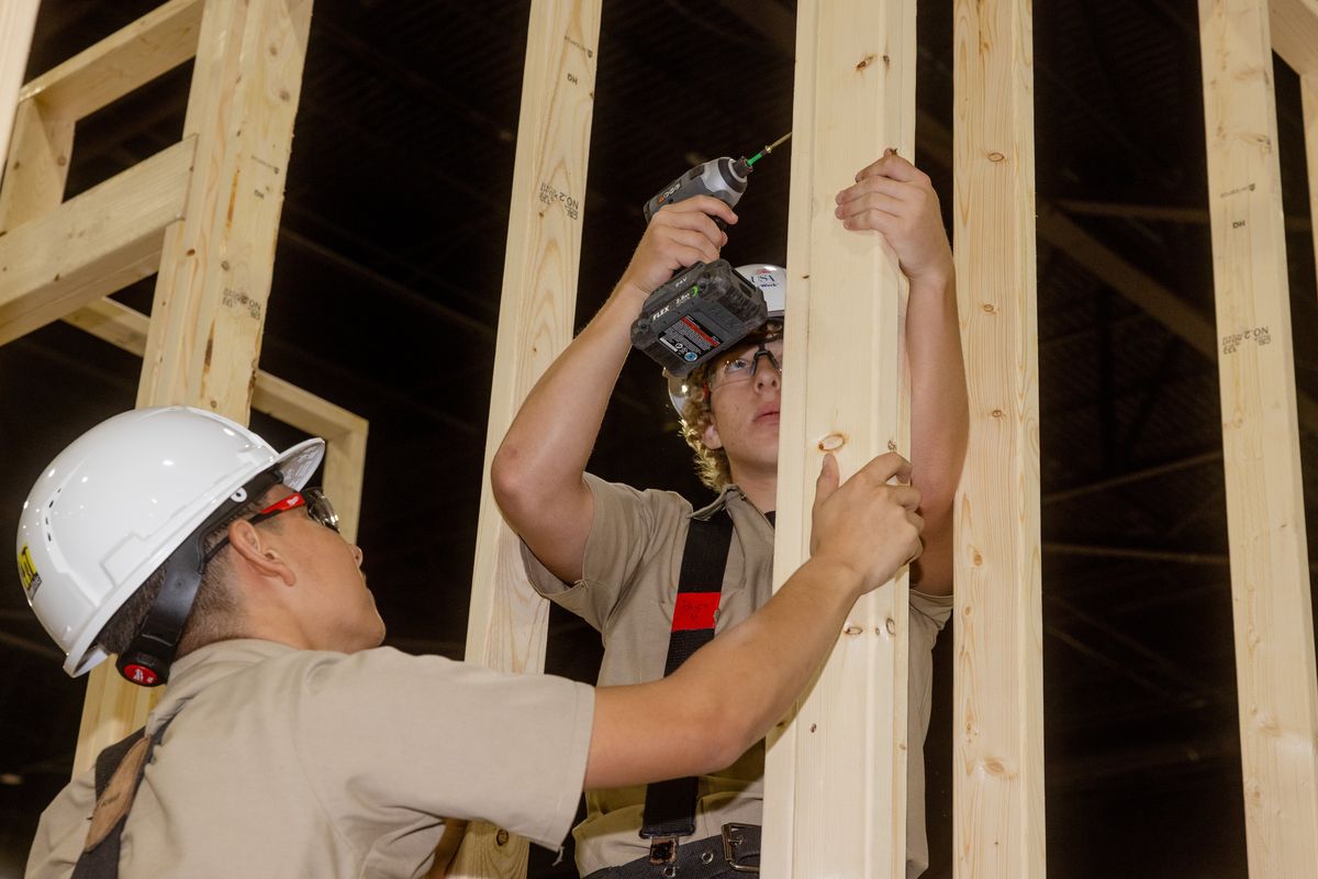 Joseph Fuentes, left, and Bryson Necessary of Belton High School in Belton, Texas, frame their team’s tiny house at the SkillsUSA Championships, in Atlanta, June 24, 2025. The Belton High team finished second to the team from SUN Area Technical Institute, in New Berlin, Pa.  (New York Times)