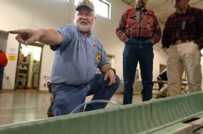 
Bob Lowe, left, of Rathdrum, talks Saturday with prospectors about a piece of equipment he built at a show for prospectors in Post Falls. Lowe makes prospecting equipment and runs a rural prospecting 