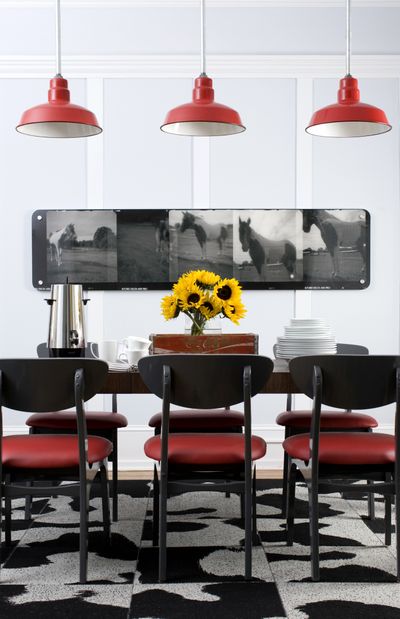 A dining room designed by Brian Patrick Flynn demonstrates how the designer balances space vertically by grounding a room with pendant lighting.