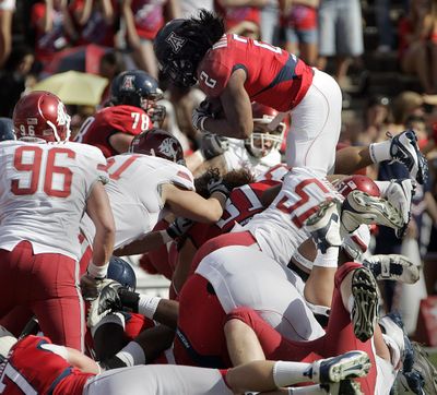 Washington State’s defense stacks up Arizona’s Keola Antolin, but can’t keep him from scoring.  (Associated Press / The Spokesman-Review)