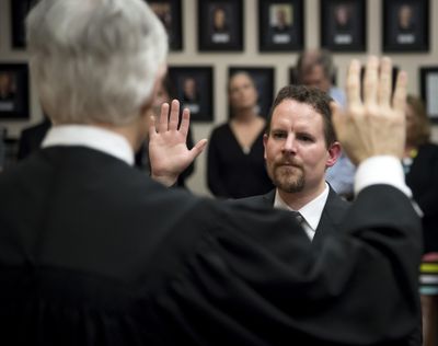 FILE – Superior Court Judge Michael Price (back to camera) swears in new Spokane County Superior Court Judge Tony Hazel during an investiture held Friday, May 5, 2017, at the Gonzaga University Law School. (Colin Mulvany / The Spokesman-Review)