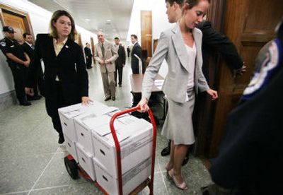 
Department of Justice personnel on Tuesday deliver documents of U.S. Supreme Court nominee John Roberts  to Capitol Hill. 
 (Associated Press / The Spokesman-Review)