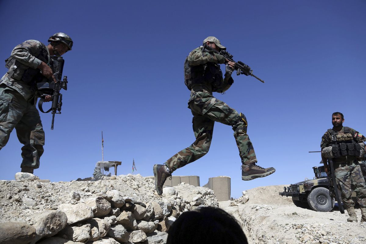 An Afghan commando jumps in Pandola village near the site of a U.S. bombing in the Achin district of Jalalabad, east of Kabul, Afghanistan, Friday, April 14, 2017. (Rahmat Gul / Associated Press)