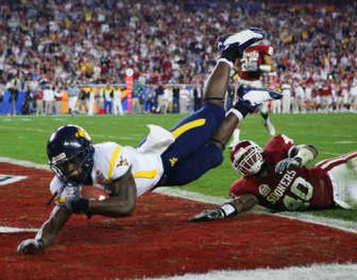 
West Virginia wide receiver Darius Reynaud  dives into the end zone for a touchdown as Oklahoma's Curtis Lofton tries for the tackle. Associated Press
 (Associated Press / The Spokesman-Review)