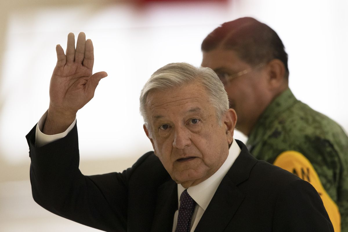 Mexican President Andres Manuel Lopez Obrador waves as he leaves after giving his daily, morning press conference, in front of the former presidential plane at Benito Juarez International Airport in Mexico City, Monday, July 27, 2020. The president, who only flies commercial as one measure in his austerity government, has been trying to sell the plane since he took office.  (Marco Ugarte)