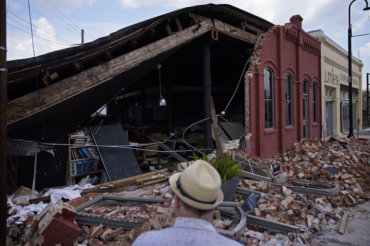 A man looks at a partially collapsed building in the aftermath of Hurricane Ida, Saturday, Sept. 4, 2021, in Houma, La. Full restoration of electricity to some of the hardest-hit areas of Louisiana battered by Hurricane Ida could take until the end of the month, the head of Entergy Louisiana warned Saturday.  (John Locher)