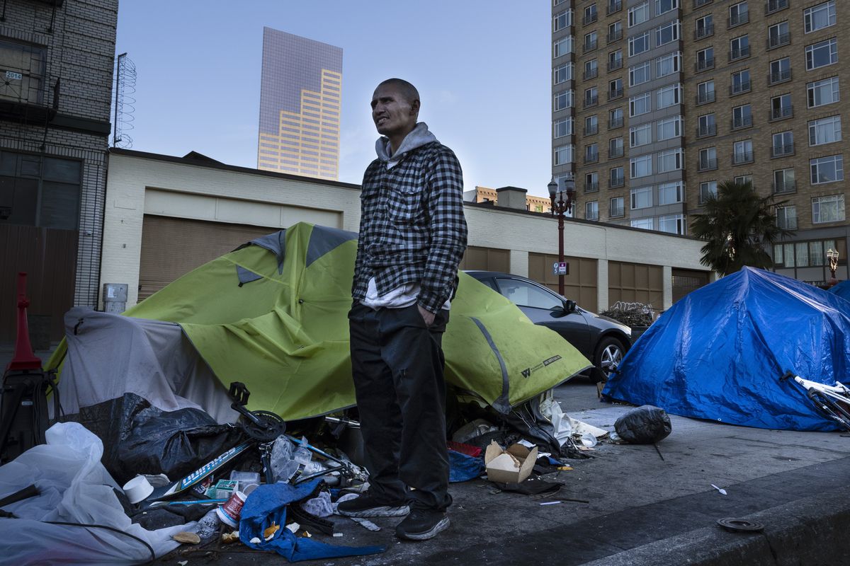 Carlos, a homeless man stands in front of his tent Friday in Portland.  (Associated Press)