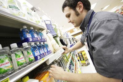 Employee Jesse McCauley stocks  phosphate-free dishwashing machine detergent at a Rosauers supermarket in Spokane on Tuesday.  (Associated Press / The Spokesman-Review)