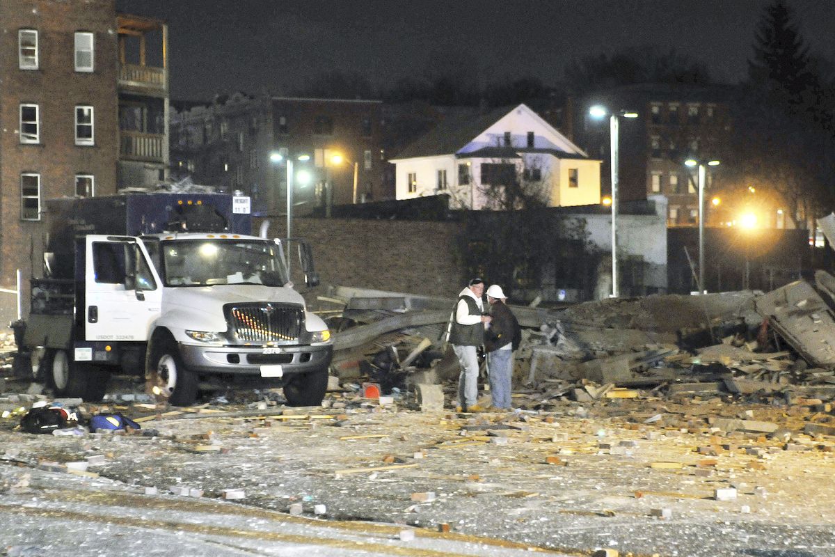 Gas company workers stand where a building once stood, which was leveled by an explosion in downtown Springfield, Mass. on Friday, Nov. 23, 2012. (Don Treeger / Springfield Republican)