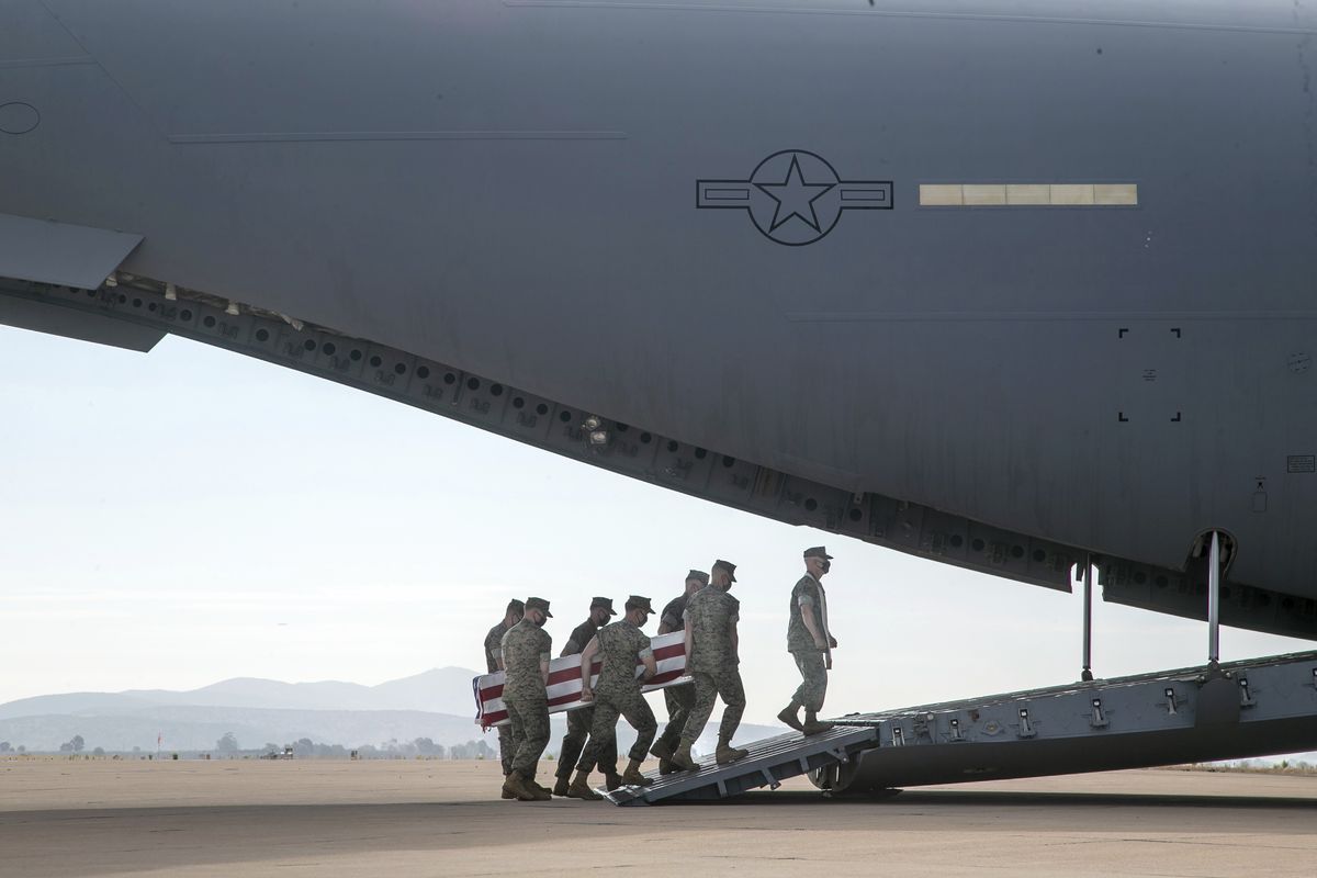 In this photo provided by the U.S. Marine Corps, U.S. Marines and sailors carry a casket aboard a U.S. Air Force C-17 Globemaster III at Marine Corps Air Station Miramar, in Calif., Wednesday, Aug. 12, 2020. The remains of seven Marines and a sailor, who died after a seafaring tank sank off the coast of Southern California last month, were transferred to Dover Air Force Base in Delaware for burial preparations.  (Staff Sgt. Kassie McDole)