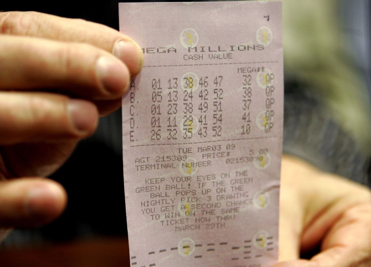 Bob Space holds up the $216 million winning Mega Millions lottery ticket Wednesday at Chubb Insurance Company in Whitehouse Station, N.J. Space and nine co-workers will share the jackpot.  (Associated Press / The Spokesman-Review)